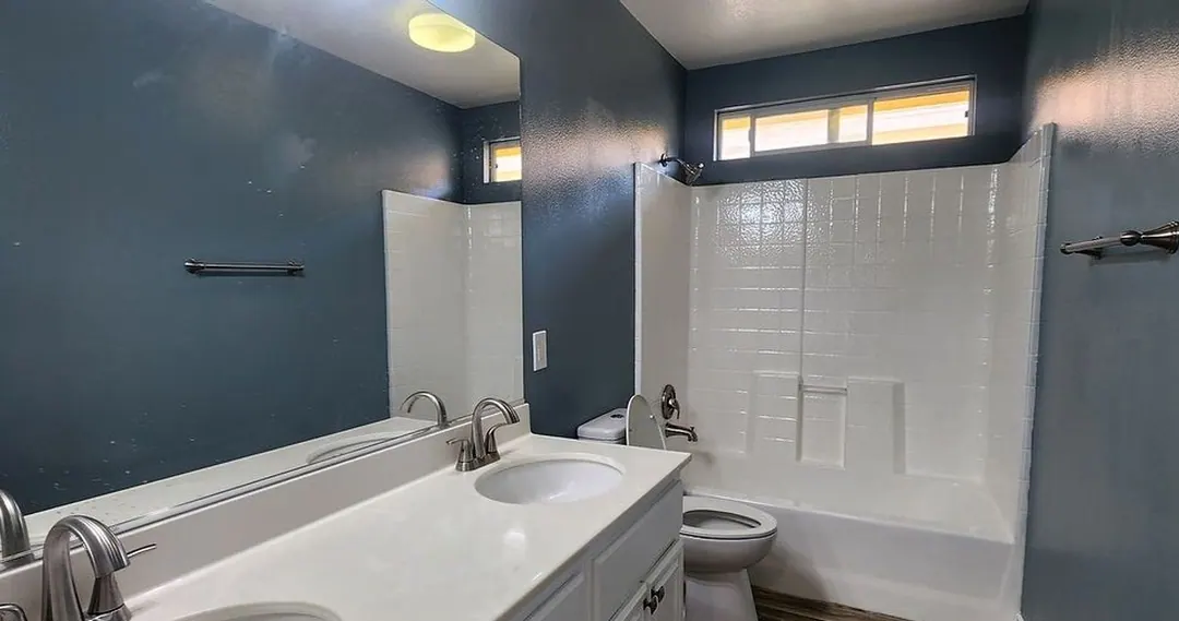 Original iPhone photo of a blue bathroom, tilted, with reflections in the mirror