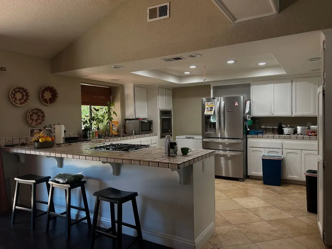 Original iPhone photo of a kitchen with full counters and a trash bin