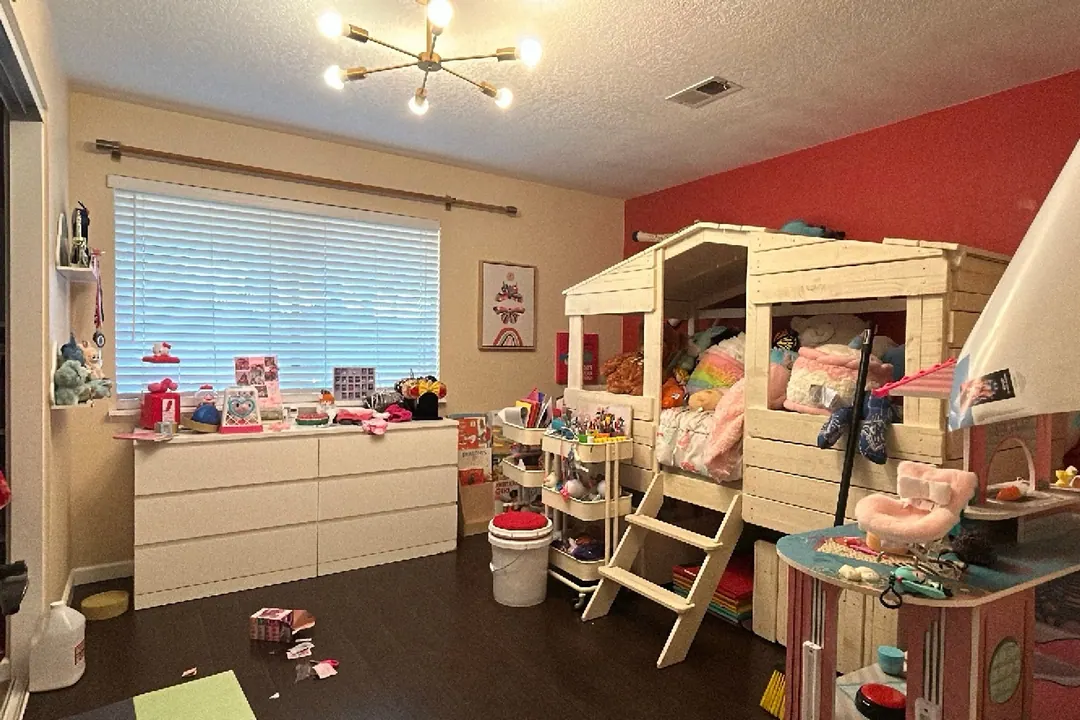 Original iPhone photo of a kid's room with toys and clothes across the floor